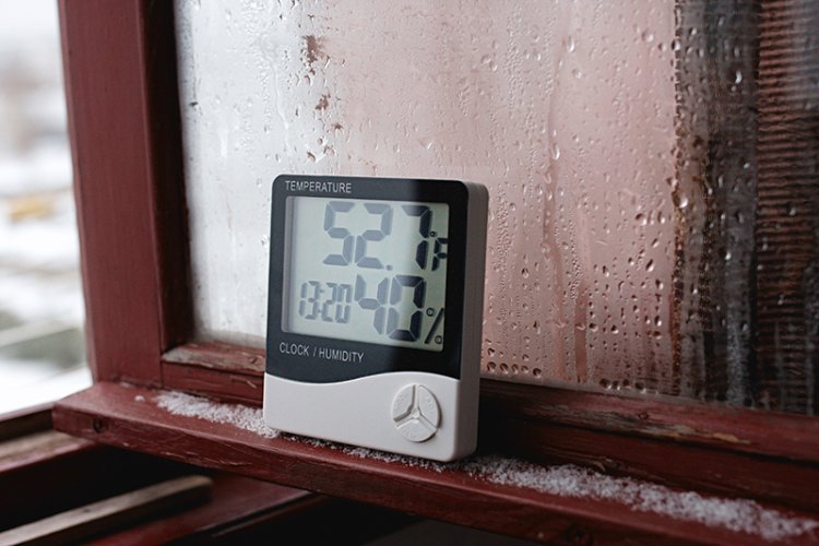 Hygrometer leaning against a window.